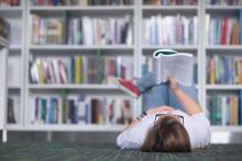 Young woman lying on the floor reading