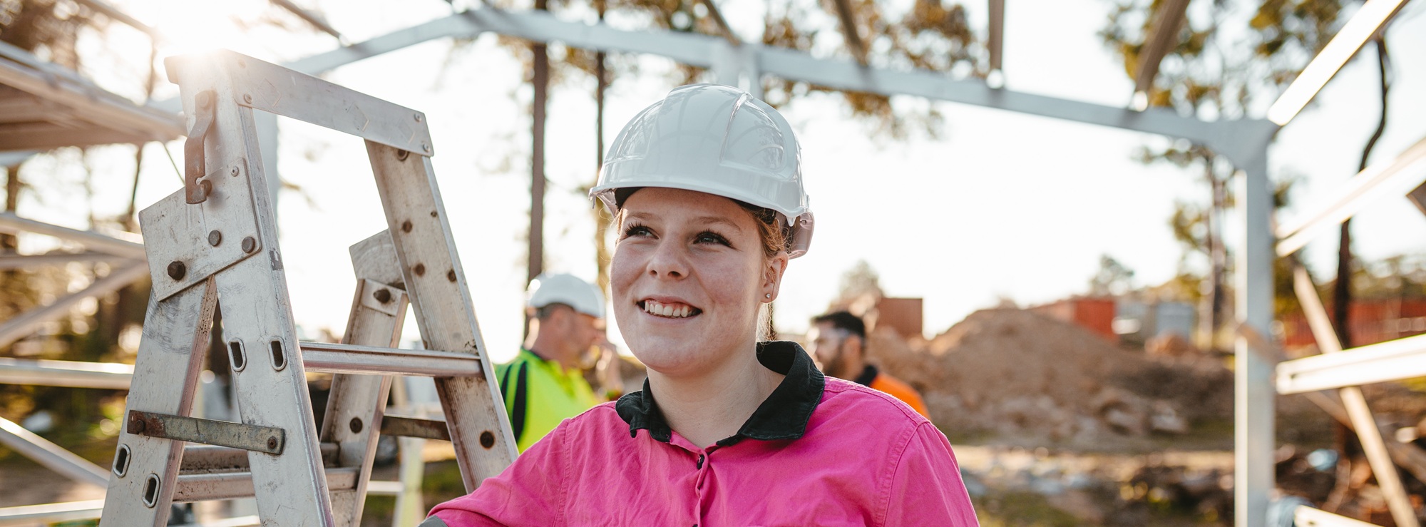 Woman wearing high vis and a hard hat at a work site